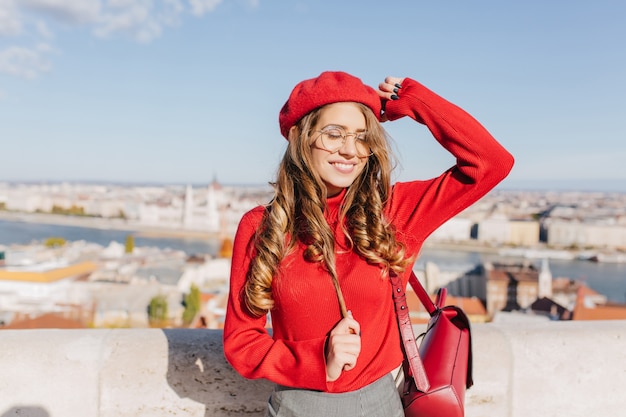 Felice ragazza caucasica gioca con i capelli castani in una giornata di sole nella capitale europea