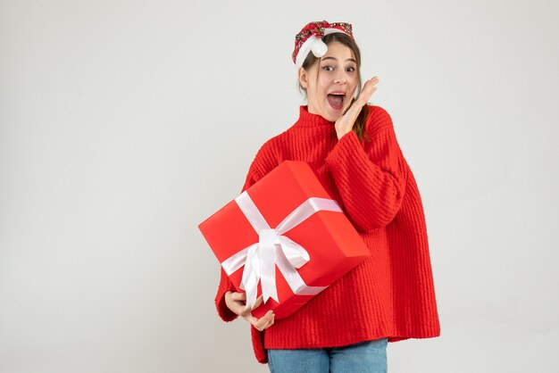 felice ragazza con cappello santa tenendo il regalo su bianco