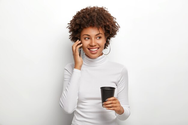 Felice ragazza positiva con taglio di capelli afro si sente bene durante la comunicazione vivace