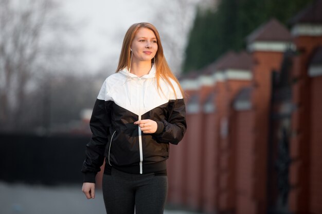 Felice ragazza sportiva sorridente a piedi