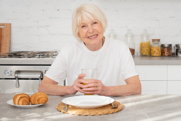 Felice senior seduto in cucina