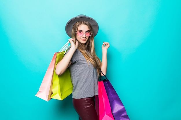 Felice shopping donna sorridente e indossa un cappello isolato su sfondo verde