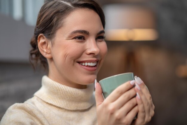 Felice signora carina godendo la sua pausa caffè