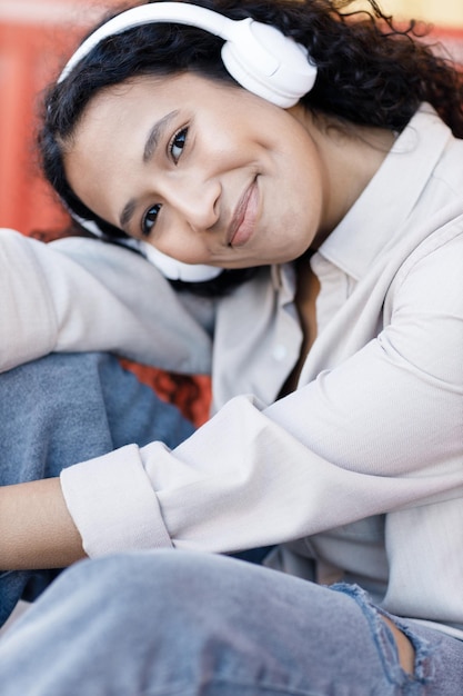 felice sorridente giovane donna all'aperto con le cuffie