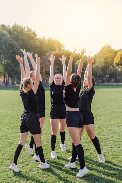 Felice squadra femminile alzando le mani