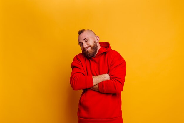 Felice uomo barbuto bello bello che indossa felpa con cappuccio in pile alla moda inverno rosso caldo