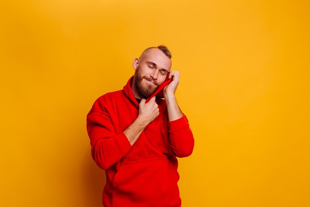 Felice uomo barbuto bello bello che indossa felpa con cappuccio in pile alla moda inverno rosso caldo