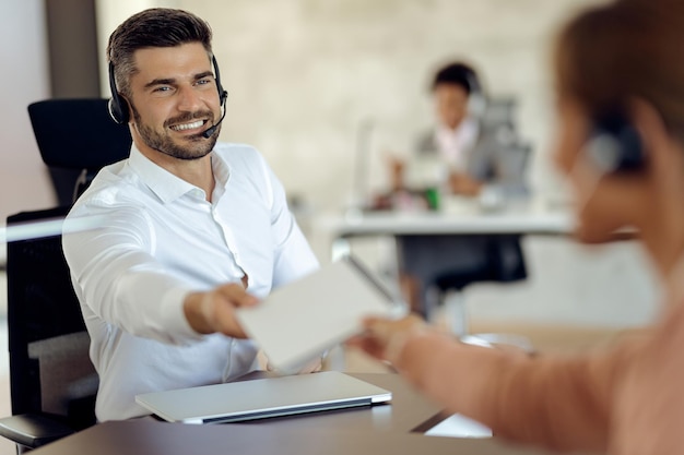 Felice uomo d'affari che collabora con il suo collega mentre lavora in ufficio