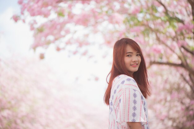 Felice viaggiatore di donna rilassarsi sentirsi libero con fiori di ciliegio o albero di fiore di Sakura in vacanza