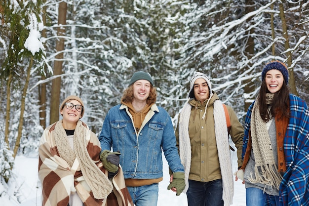 Felici giovani amici nella foresta invernale