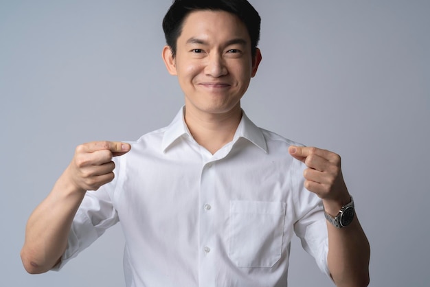 felicità intelligente attraente maschio asiatico camicia bianca mano finta che tiene carta nel petto per il testo delle tue idee