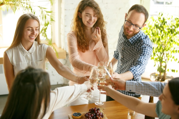 Felicità. Persone che tintinnano bicchieri di vino o champagne.