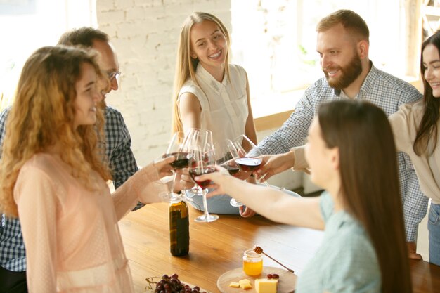 Felicità. Persone che tintinnano bicchieri di vino o champagne.