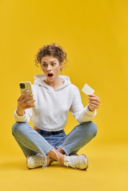 Femmina abbastanza giovane che si siede sulle gambe sul pavimento