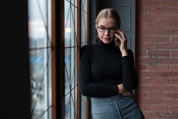 Femmina accanto alla finestra parlando al telefono