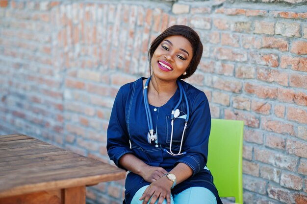 Femmina afroamericana del medico con lo stetoscopio poste all'aperto