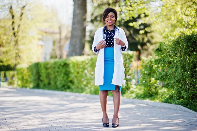 Femmina afroamericana del medico con lo stetoscopio poste all'aperto