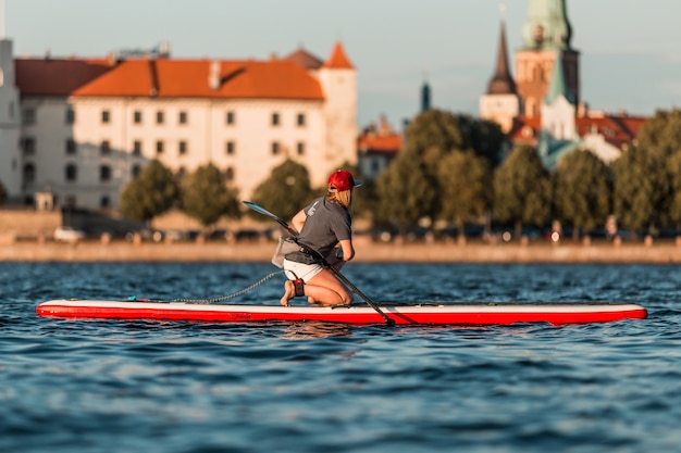 Femmina bionda su paddleboard nella Vecchia Riga, Lettonia