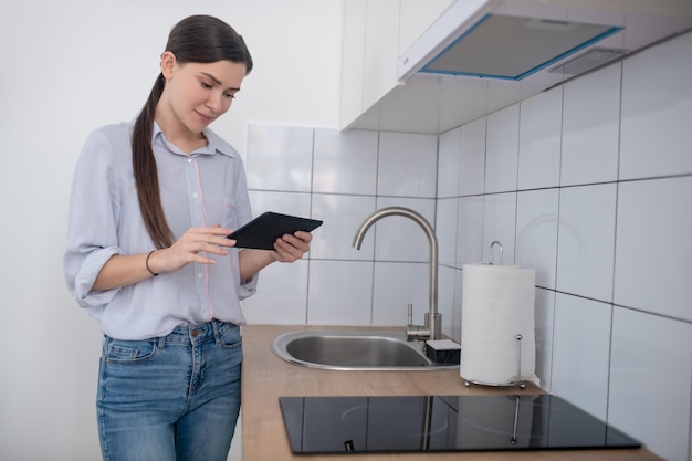 Femmina che attiva il piano cottura con un tablet