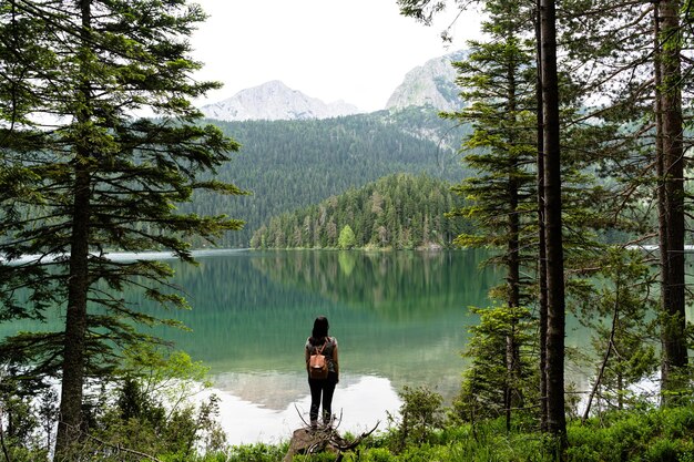 Femmina con uno zaino che gode della vista del Lago Nero nel Parco Nazionale del Durmitor, Montenegro