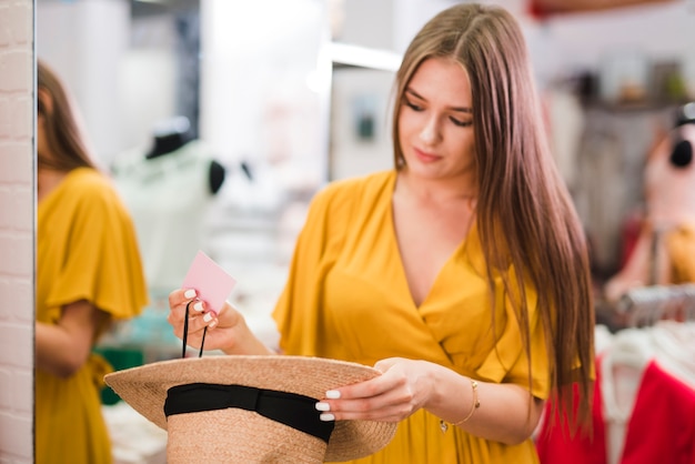 Femmina del colpo medio che tiene un cappello