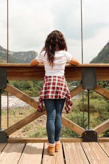 Femmina di vista frontale sulla natura piena d'ammirazione del ponte