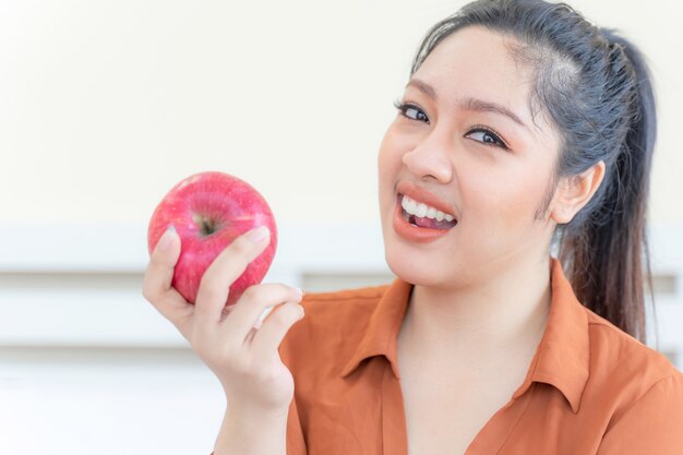 Femmina grassoccia asiatica in sovrappeso con la mela