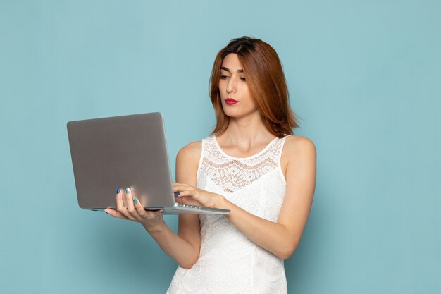 femmina in abito bianco utilizzando laptop