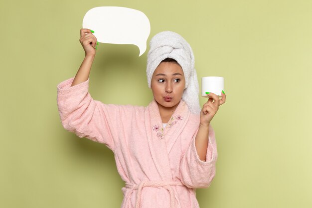 femmina in accappatoio rosa con cartello bianco e crema