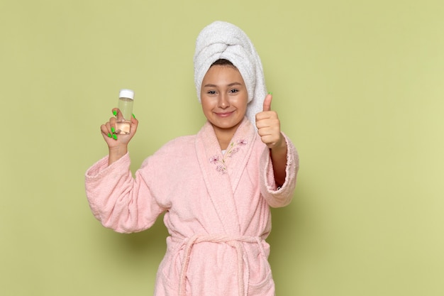 femmina in accappatoio rosa con il sorriso sul suo viso tenendo il pallone spray