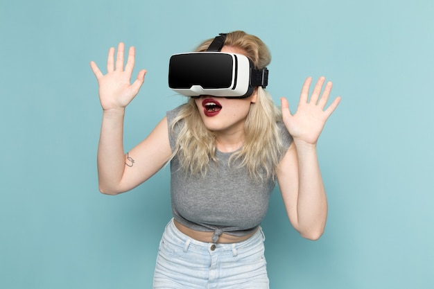 femmina in camicia grigia e blue jeans luminosi che giocano vr