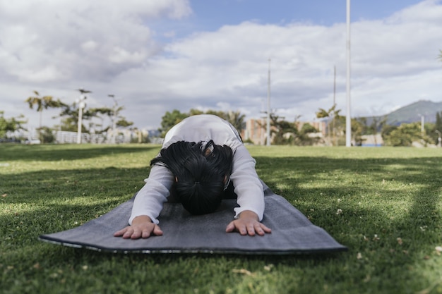 Femmina ispanica che fa yoga in un parco