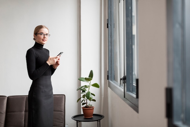 Femmina moderna di vista laterale con il cellulare