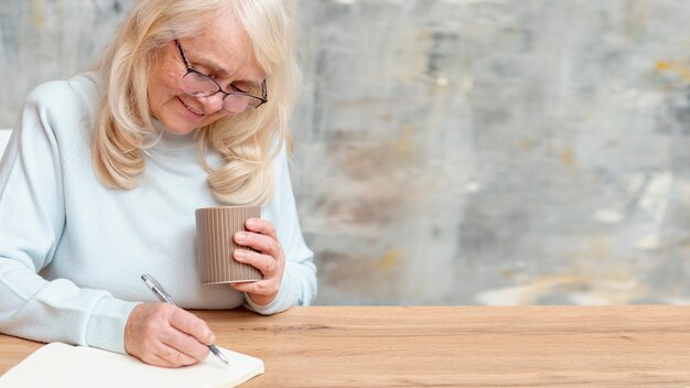 Femmina più anziana dell'angolo alto che prende le note