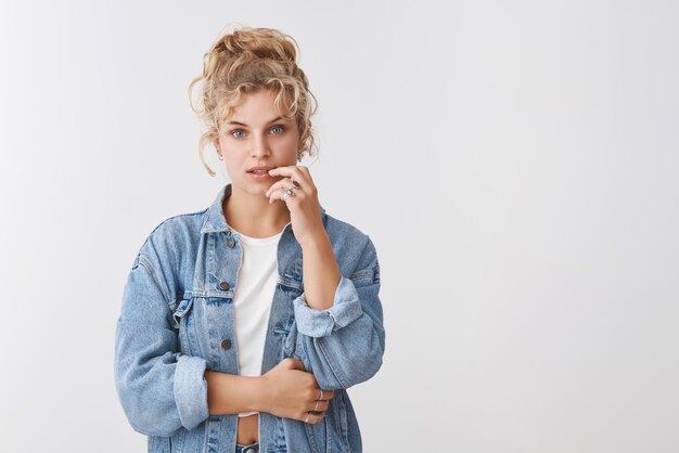 Femmina premurosa che tocca il labbro pensando e guardando concentrata