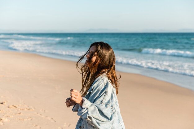 Femmina sorridente che ride sulla spiaggia in sole