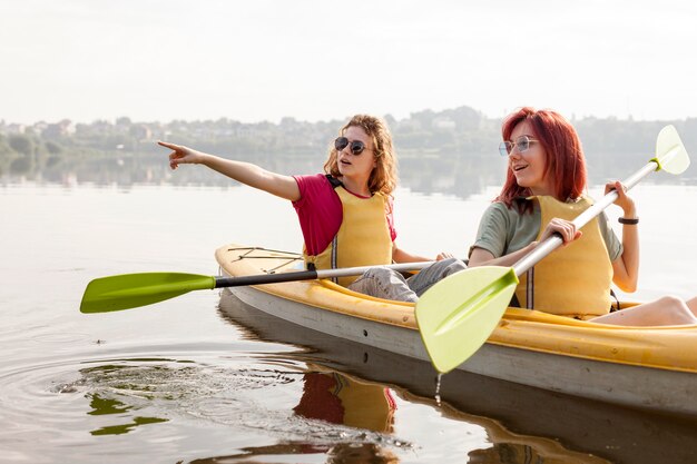 Femmine canottaggio in kayak sul lago