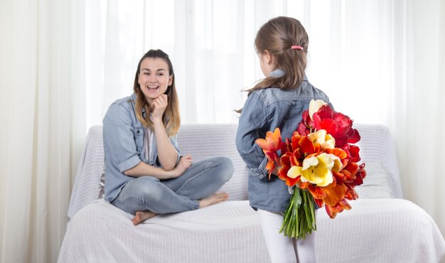 Festa della mamma. La piccola figlia con i fiori si congratula con sua madre