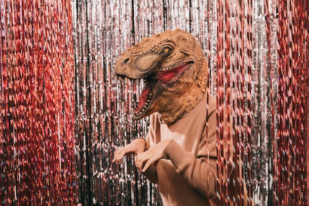 Festa di carnevale ad alto angolo con costume di dinosauro