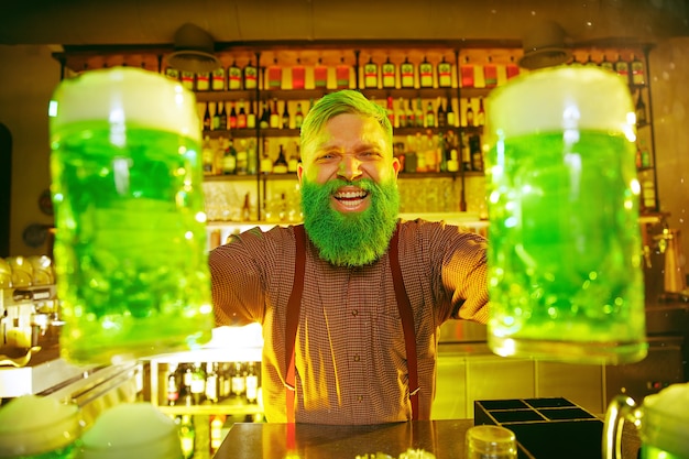 Festa di San Patrizio. Gli amici felici stanno festeggiando e bevendo birra verde.