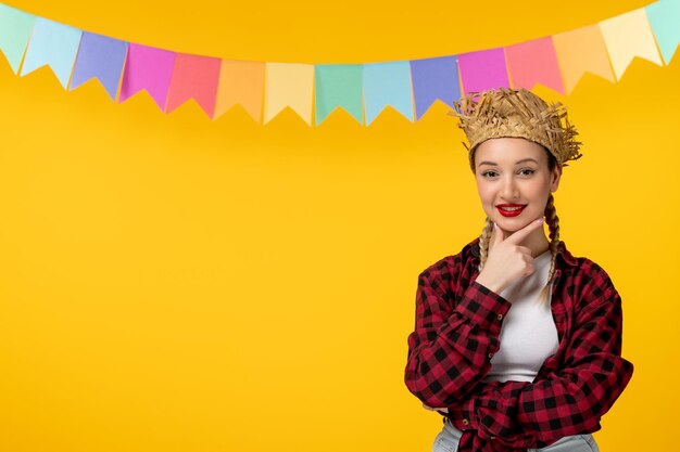 Festa junina bionda ragazza carina in cappello di paglia festival brasiliano con bandiere colorate che sorridono felicemente