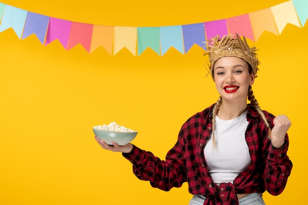 Festa junina bionda ragazza carina in cappello di paglia festival brasiliano eccitato con popcorn