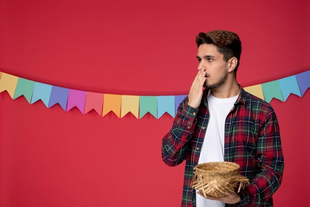 Festa junina felice ragazzo carino che indossa un cappello di paglia che celebra il festival brasiliano scioccato