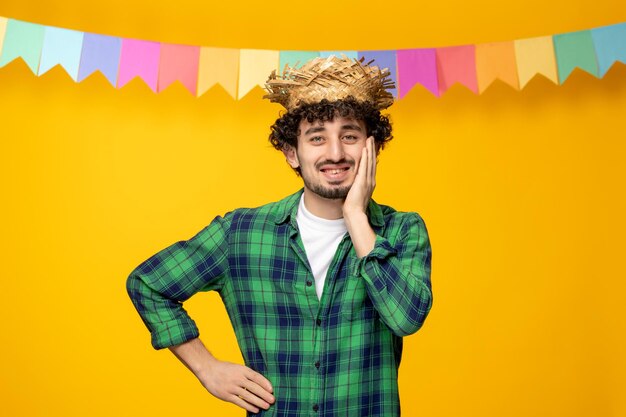 Festa junina giovane ragazzo carino con cappello di paglia e bandiere colorate festival brasiliano che copre il viso