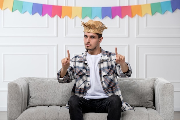 Festa junina giovane uomo carino in camicia a quadri con cappello di paglia che celebra il festival che mostra il segnale di stop