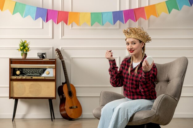 Festa junina ragazza carina con cappello di paglia brasiliano di mezza estate con chitarra radiofonica retrò che si trucca