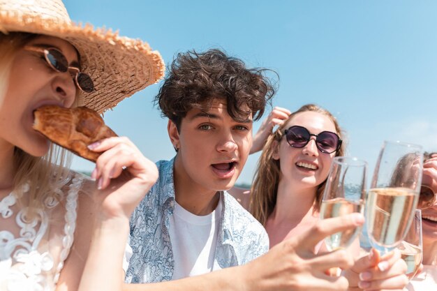 Festa stagionale al resort sulla spiaggia. Chiudere le mani degli amici che celebrano, riposano, si divertono, tintinnano