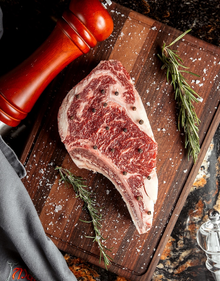 Foto gratuito fetta della carne cruda con sale sullo scrittorio di taglio