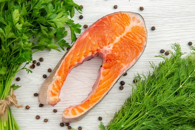 Fetta di carne cruda vista dall'alto con verdure su sfondo bianco