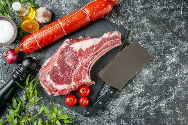 Fetta di carne fresca vista dall'alto con toamtoes su sfondo grigio chiaro animale mucca carne di pollo macellaio cibo cucina colore